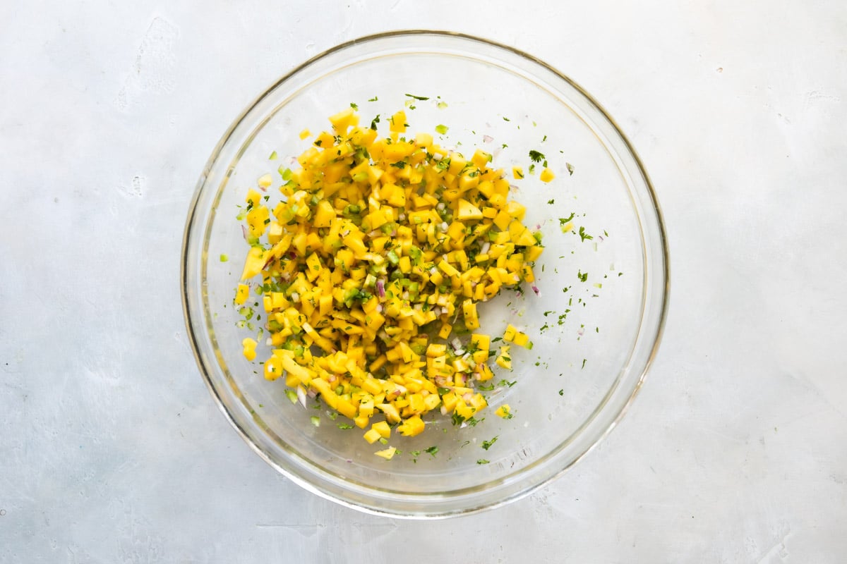 Mango salsa after being mixed in a clear bowl.