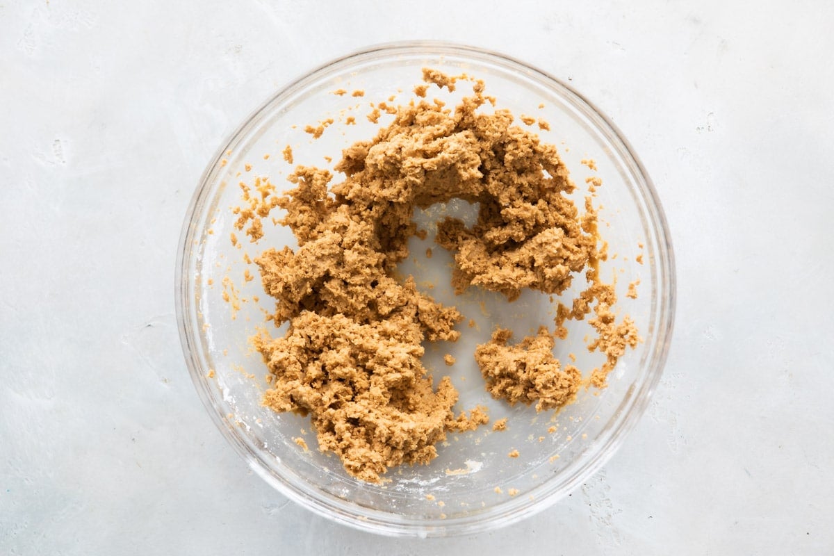 Mixture for no bake peanut butter balls in a clear bowl.