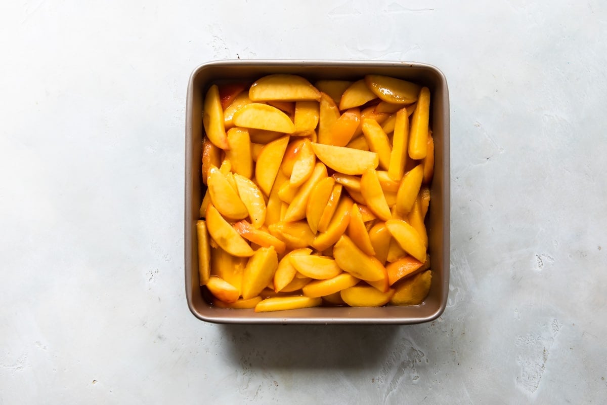 Peaches in a baking dish for cobbler.