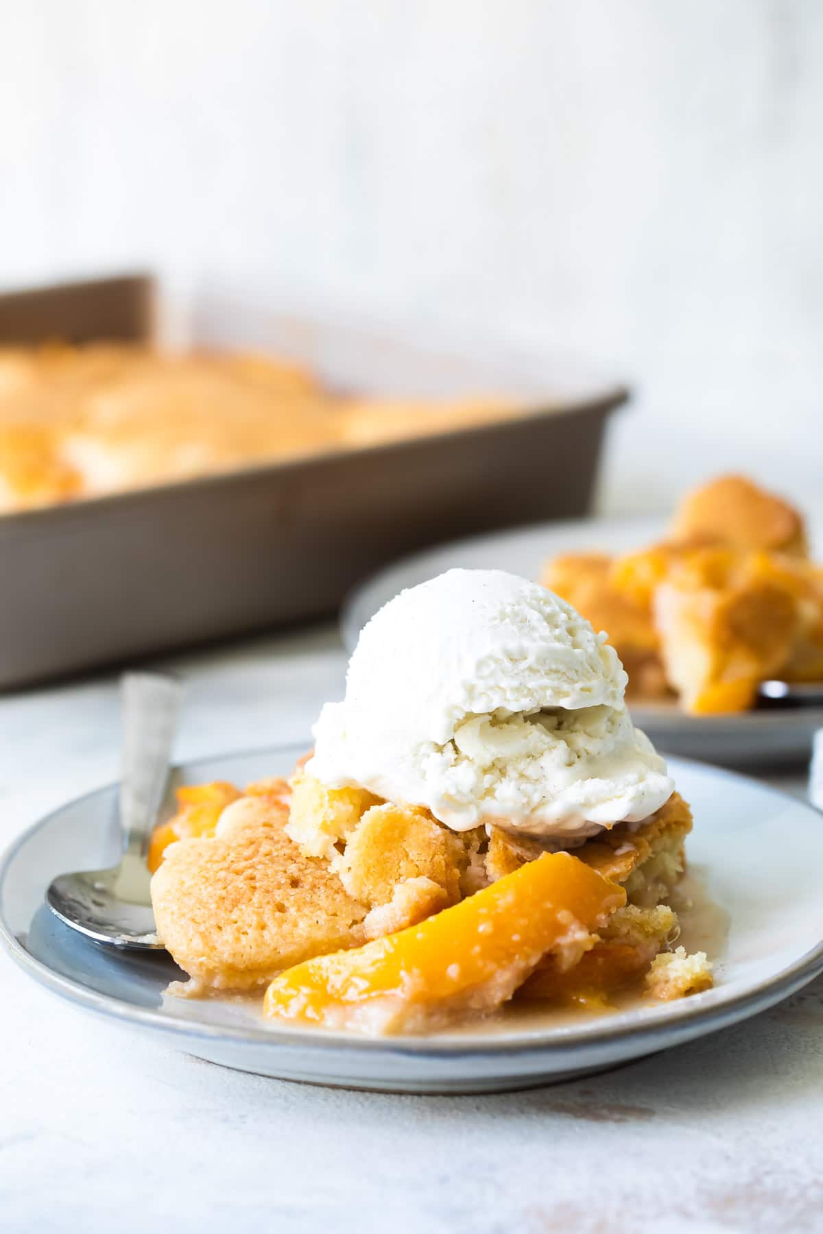 A plate of peach cobbler with vanilla ice cream.