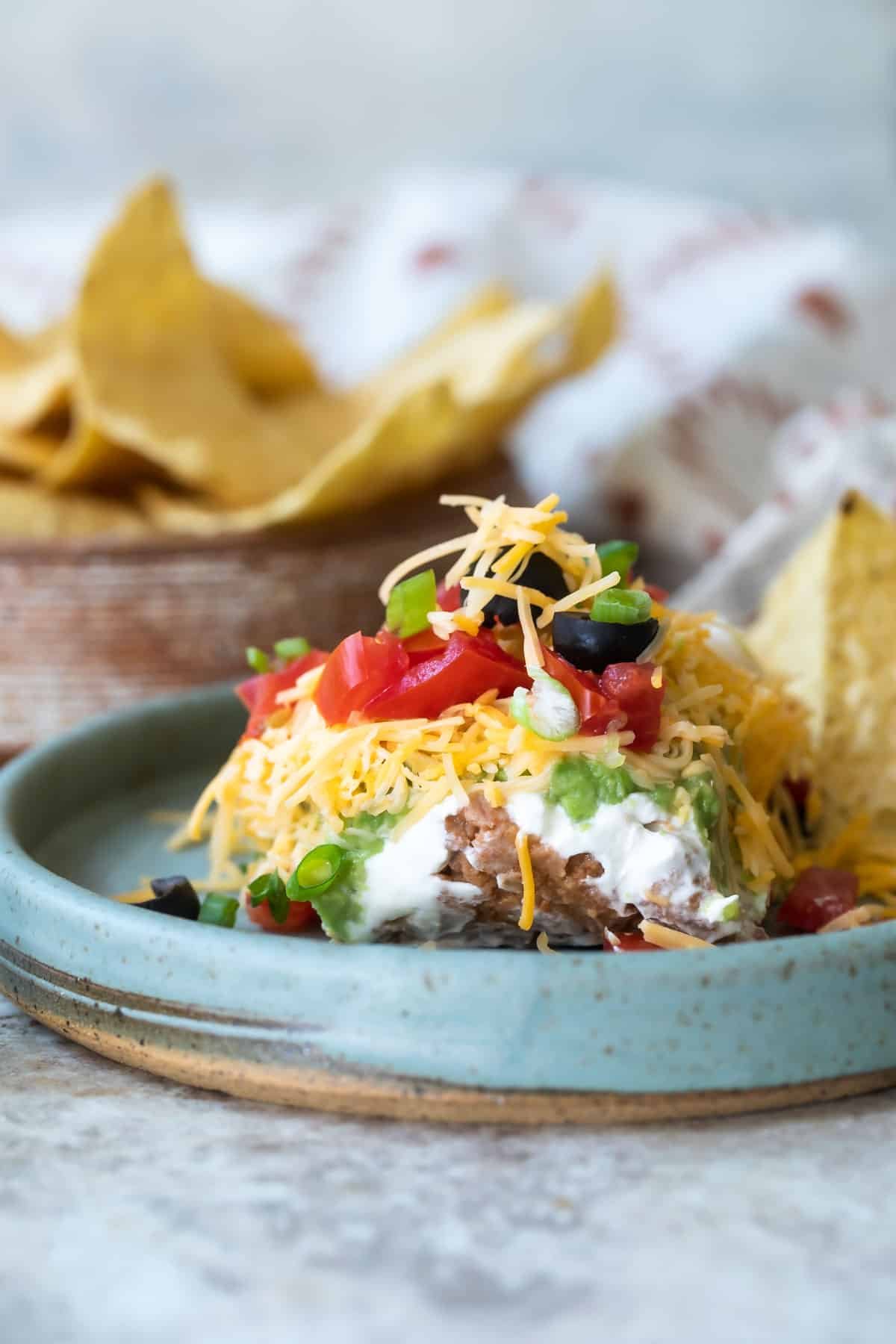Seven layer dip on a blue platee.