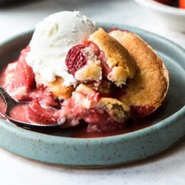 A dish of strawberry cobbler with ice cream.