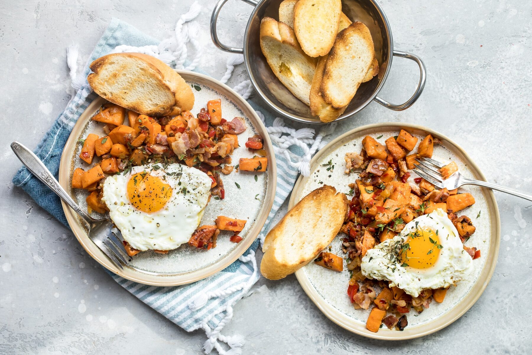 Sweet potato hash on two white plates.