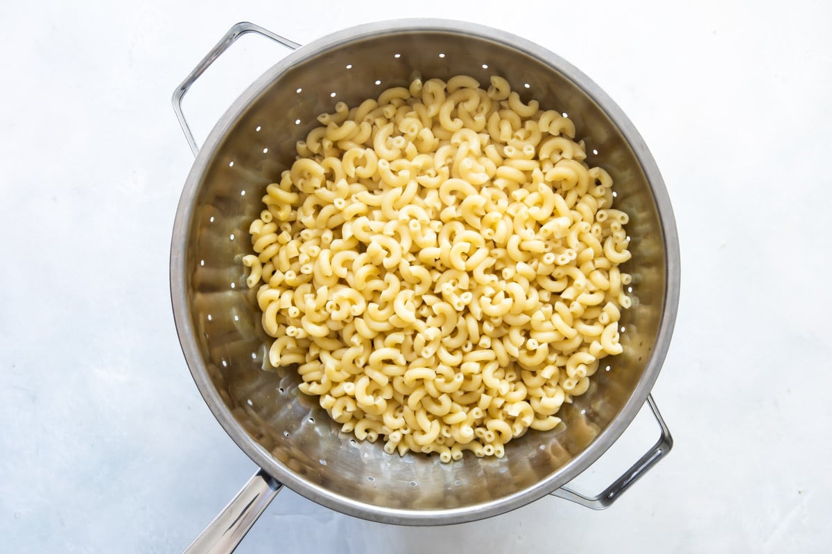 Cooked elbow macaroni in a colander.