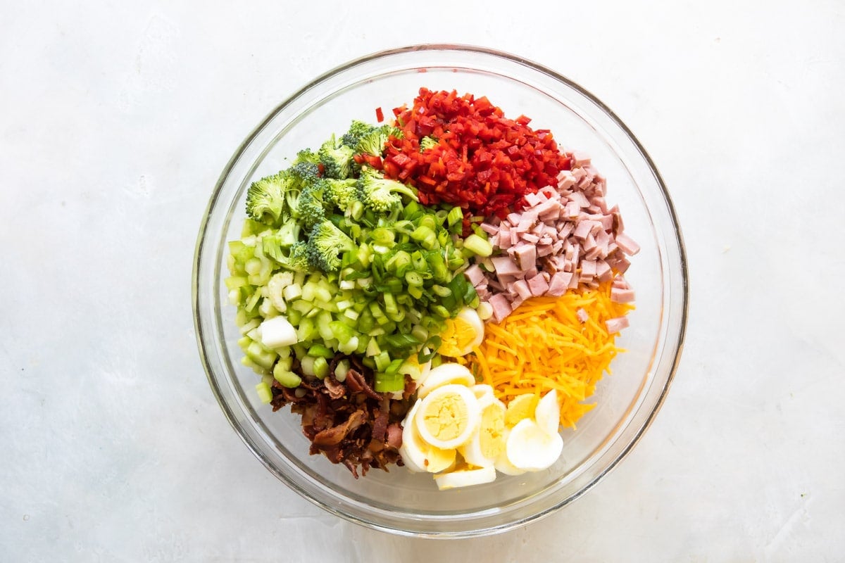 A bowl with ingredients for macaroni salad.