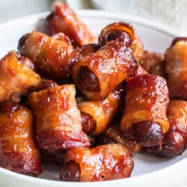 Bacon wrapped smokies in a white bowl.