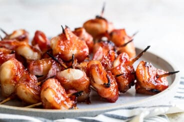 Bacon wrapped water chestnuts on a gray plate.