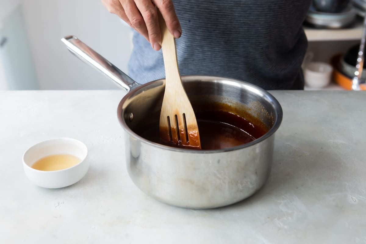 Ingredients for barbecue sauce being stirred in a saucepan