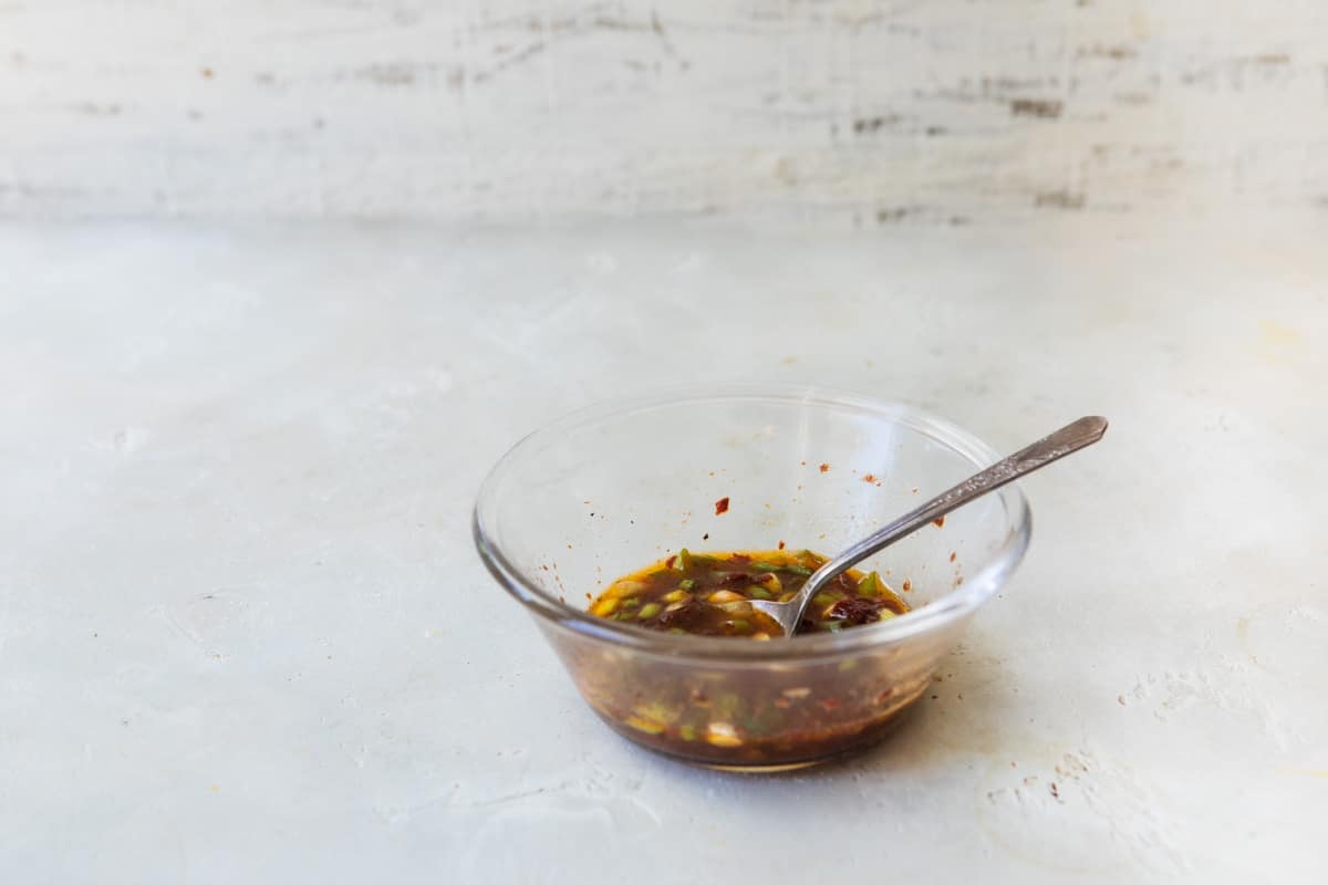 Dressing for black bean salad in a clear bowl.
