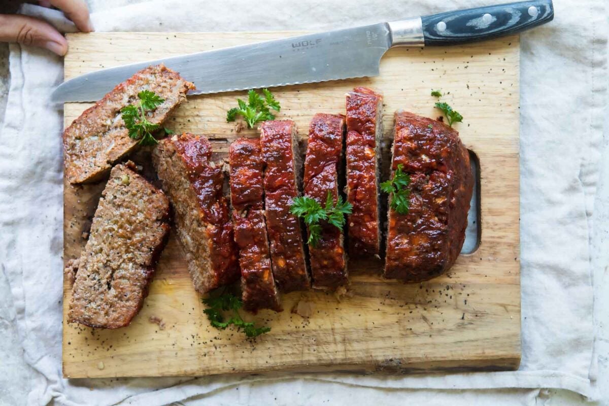 Sliced meatloaf on a cutting board.