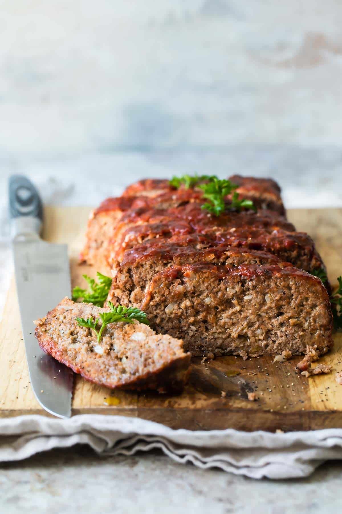 Meatloaf slices on a wooden cutting board.