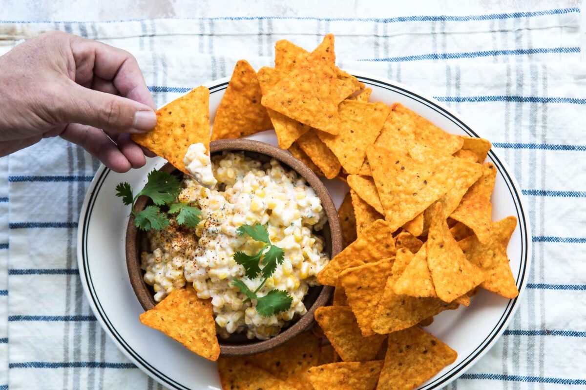 Mexican corn salad in a brown bowl.