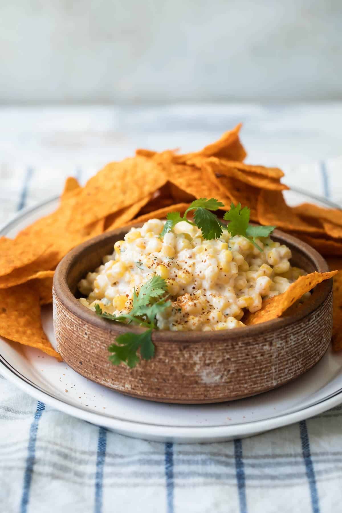 Mexican corn salad in a brown bowl.