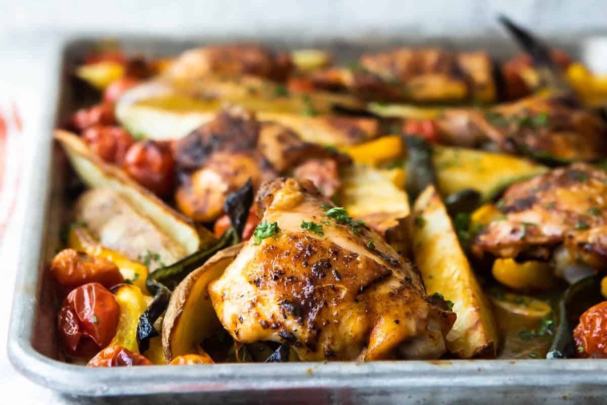 Paprika chicken and vegetables on a baking sheet.