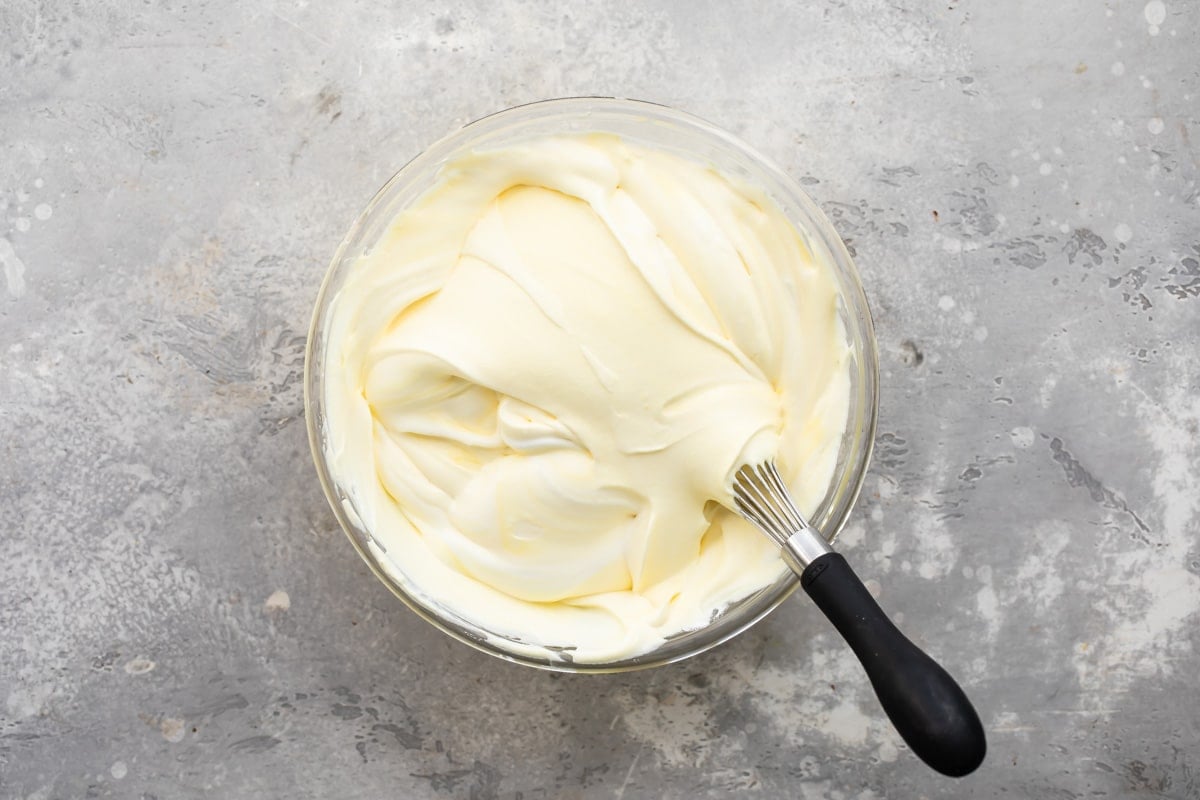 Pudding and cool whip whisked in a clear bowl.