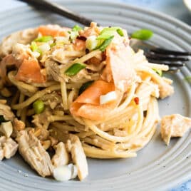 Thai peanut chicken noodles on a gray plate.