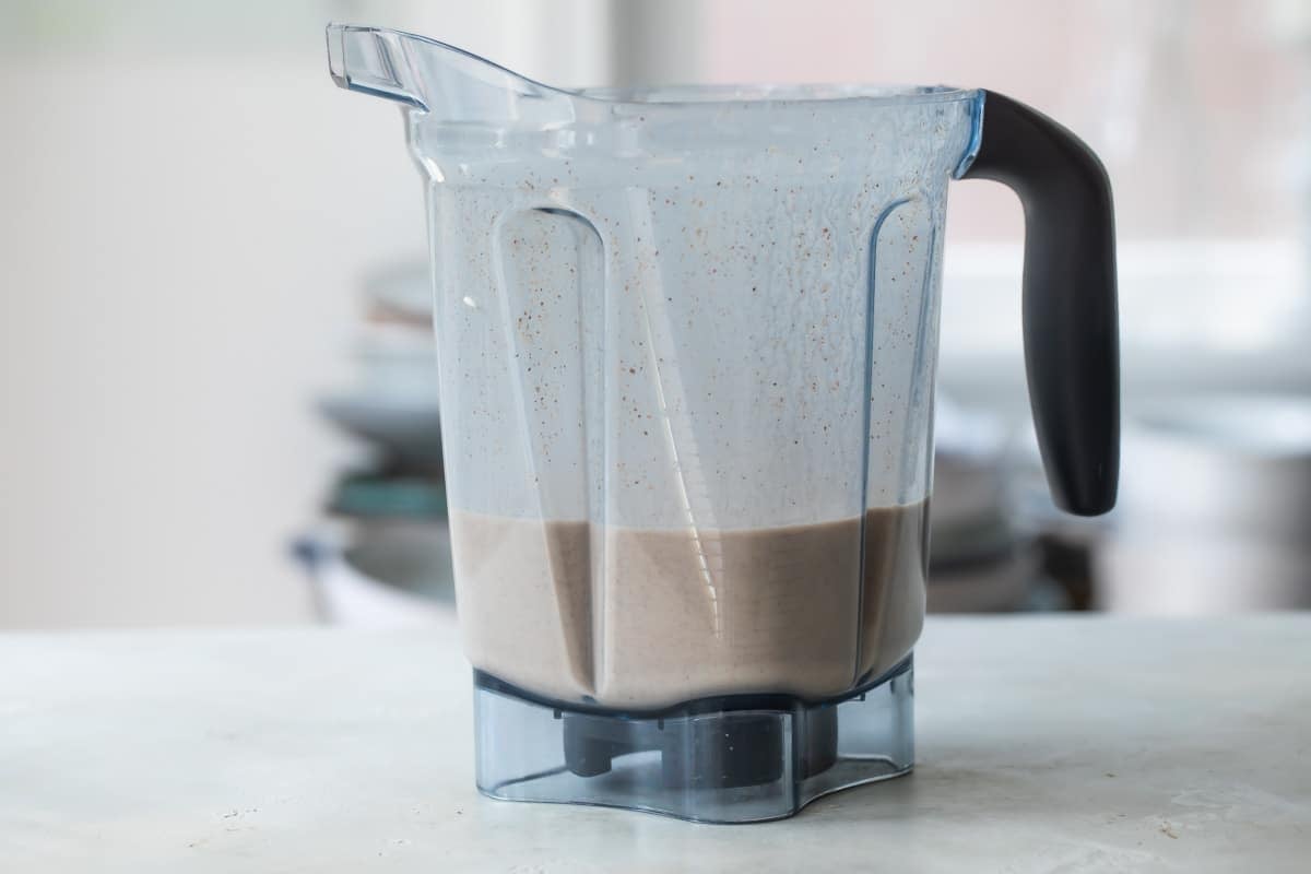 Blending rice and cinnamon in a blender to make horchata.
