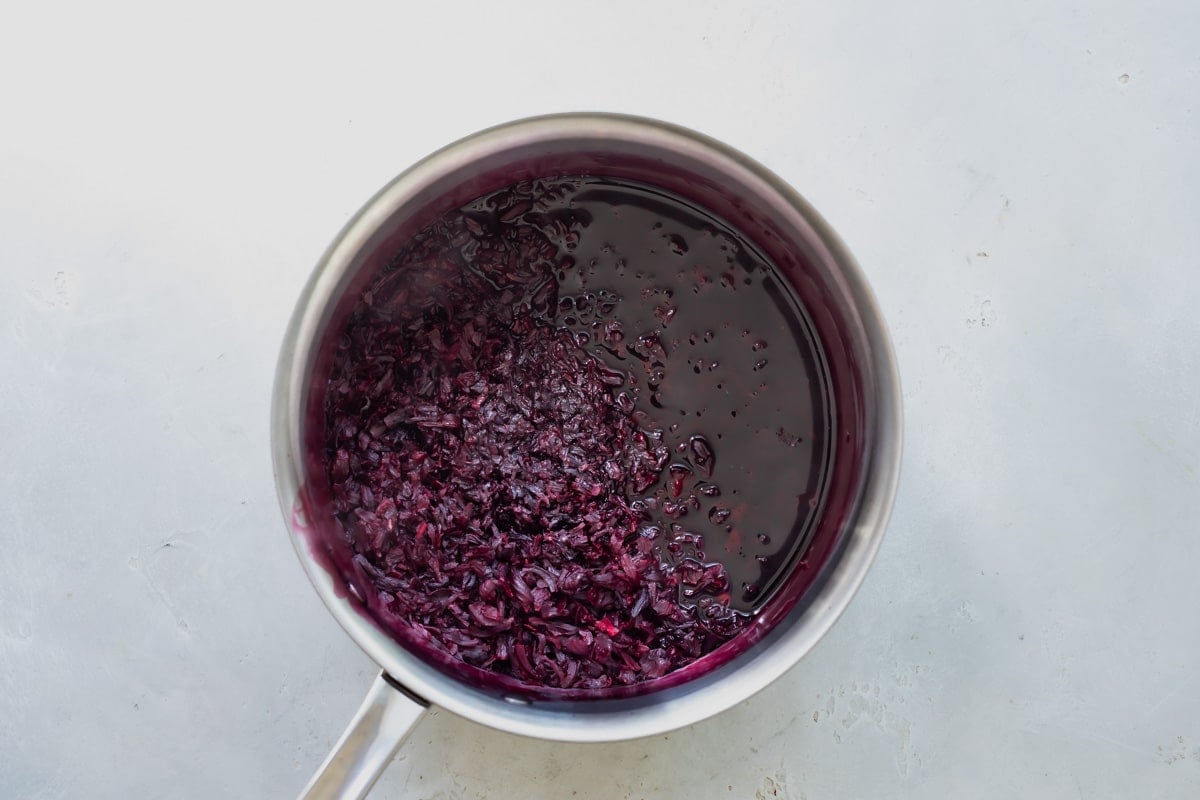 A saucepan with Jamaica (Hibiscus) flowers in it being hydrated in water.