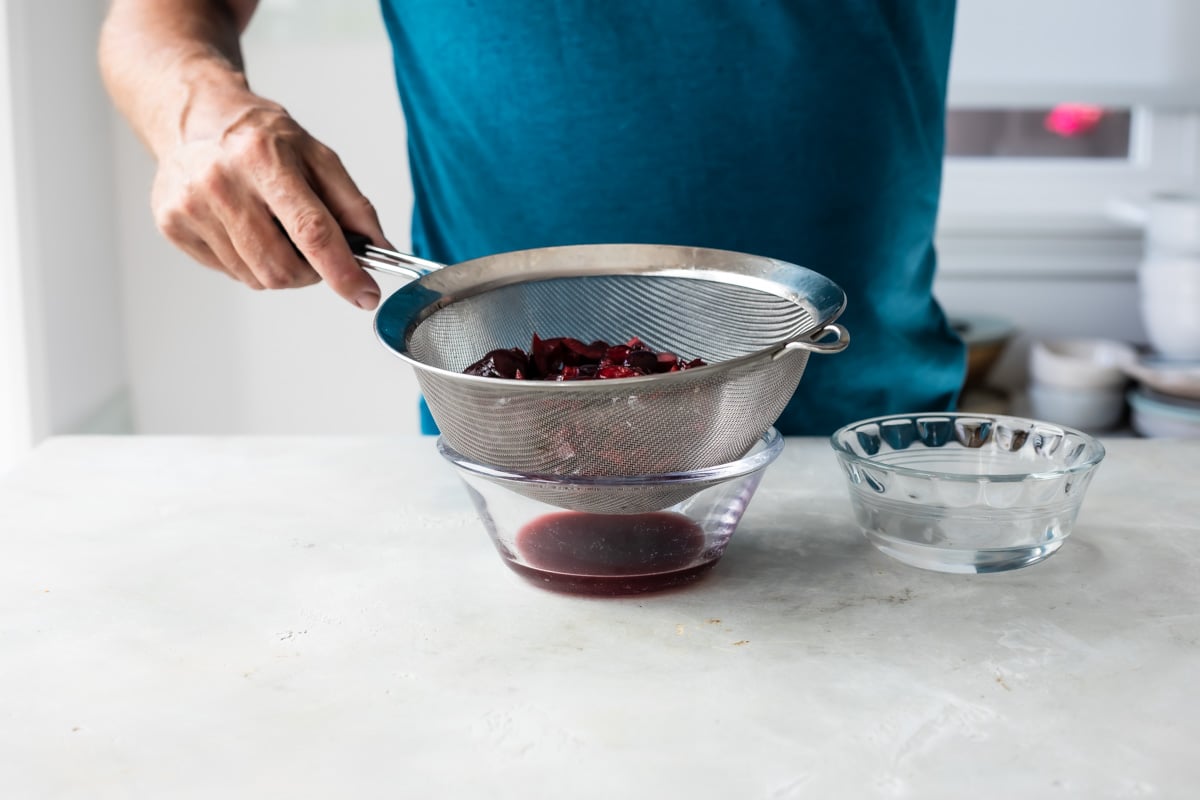 Draining cherries in a strainer.