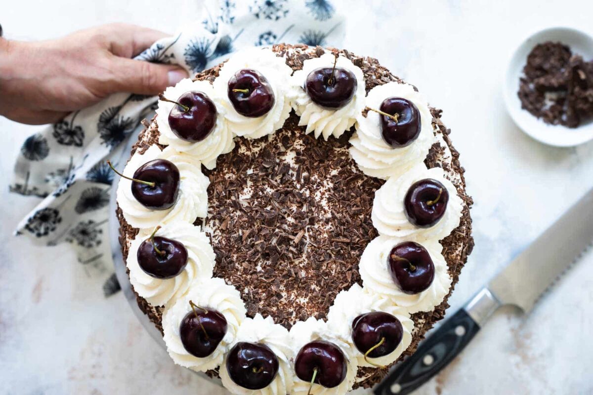 A frosted Black Forest Cake on a platter.