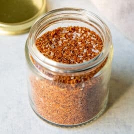 A small glass jar full of dry rub seasoning.