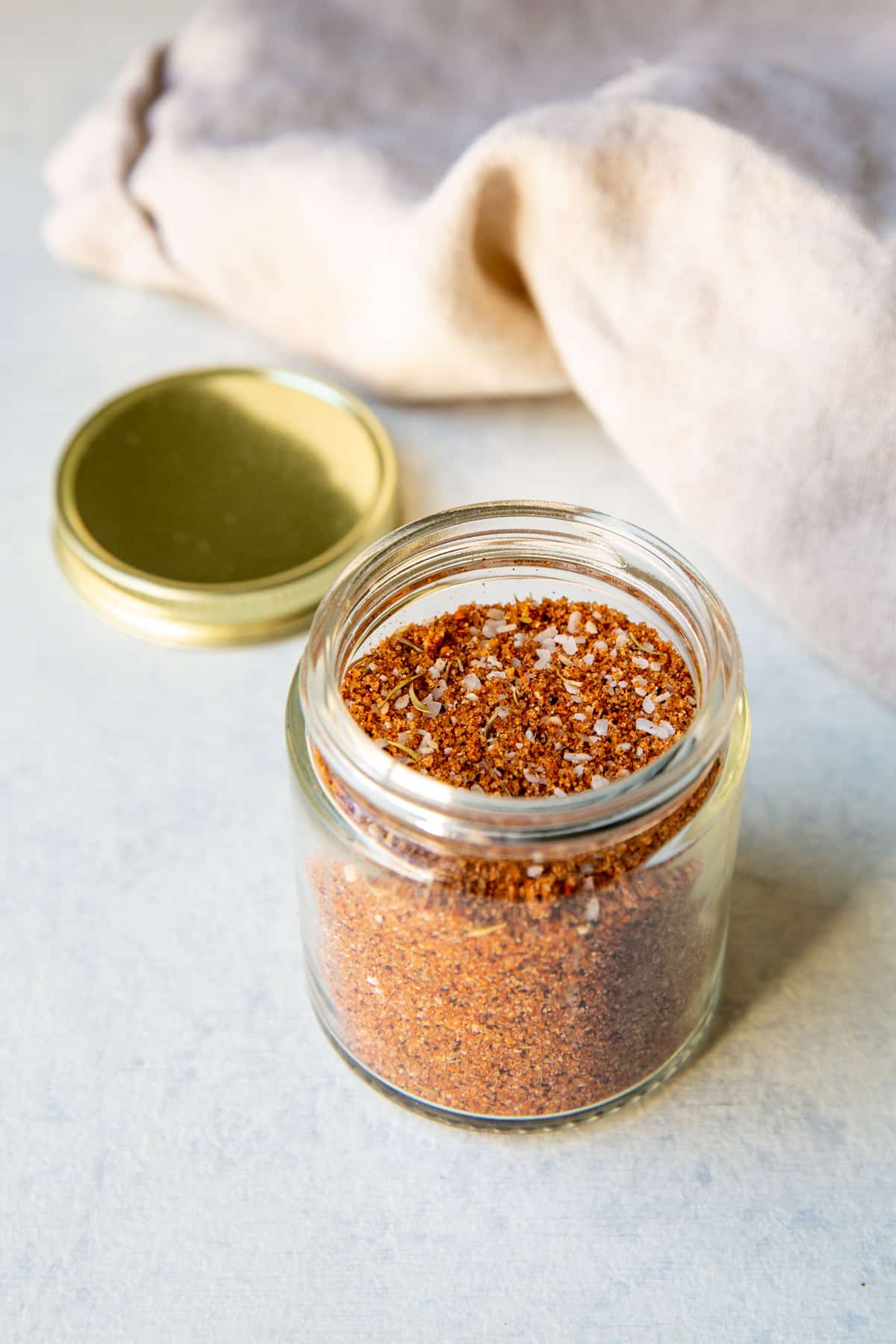 A small glass jar full of dry rub seasoning.