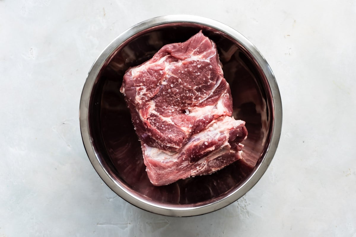 A raw pork roast in a Dutch oven.