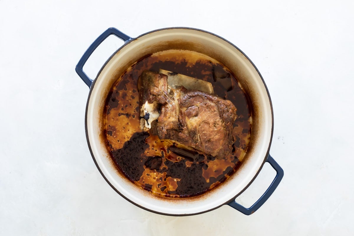 A cooked pork roast in a Dutch oven.