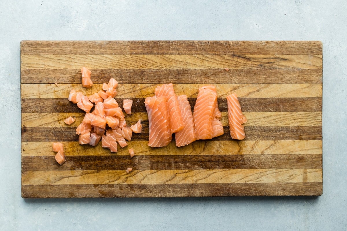 An overhead shot of salmon on a wooden cutting board.