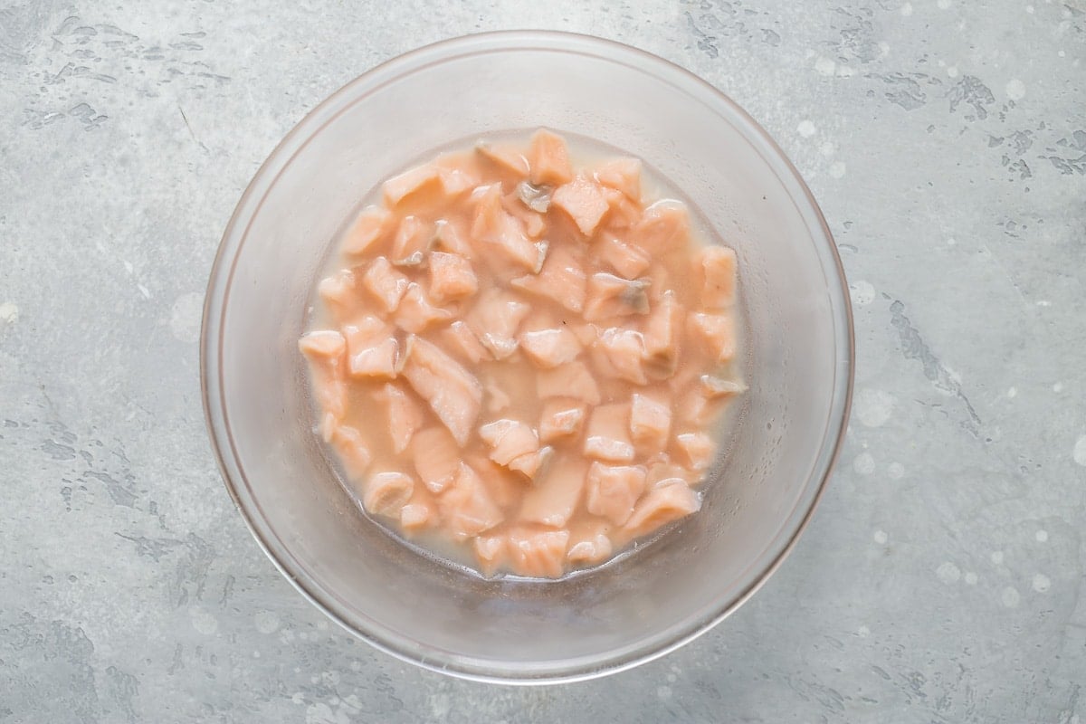 An overhead shot of salmon ceviche ingredients in a clear bowl.