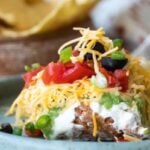 Seven layer dip on a blue platee.