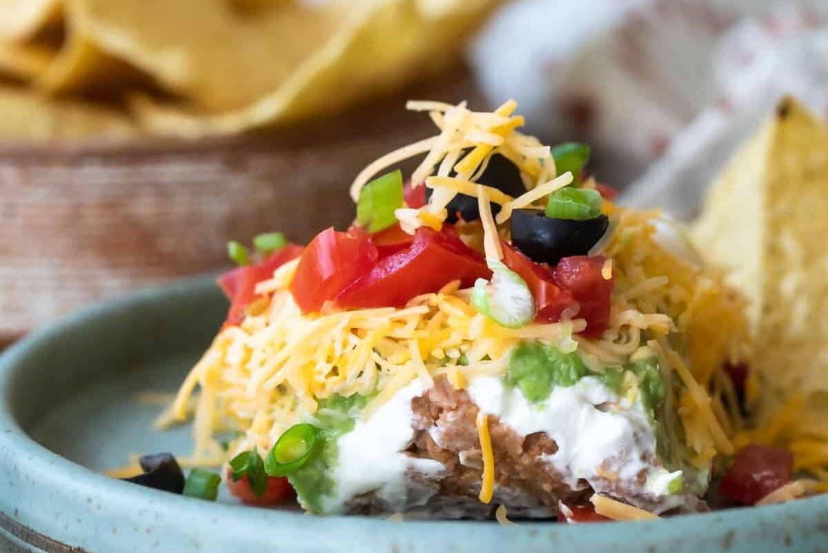 Seven layer dip on a blue platee.