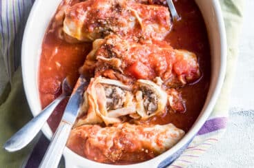 Stuffed cabbage rolls in a white baking dish.