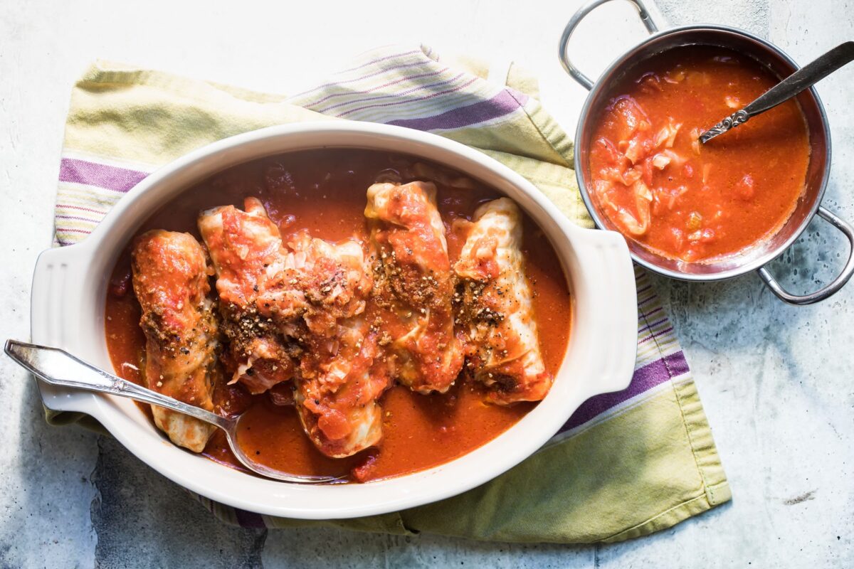 Stuffed cabbage rolls in a white baking dish.