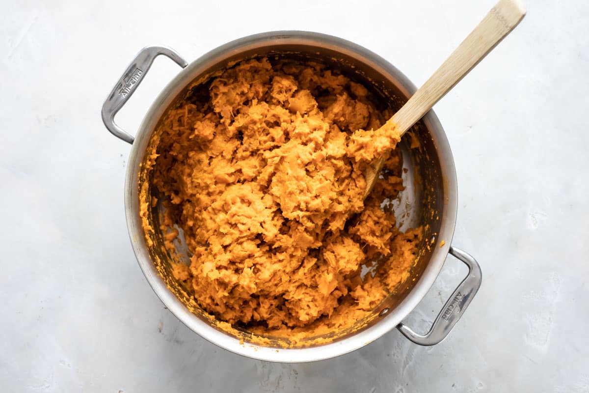 Mashed sweet potatoes in a silver pot.