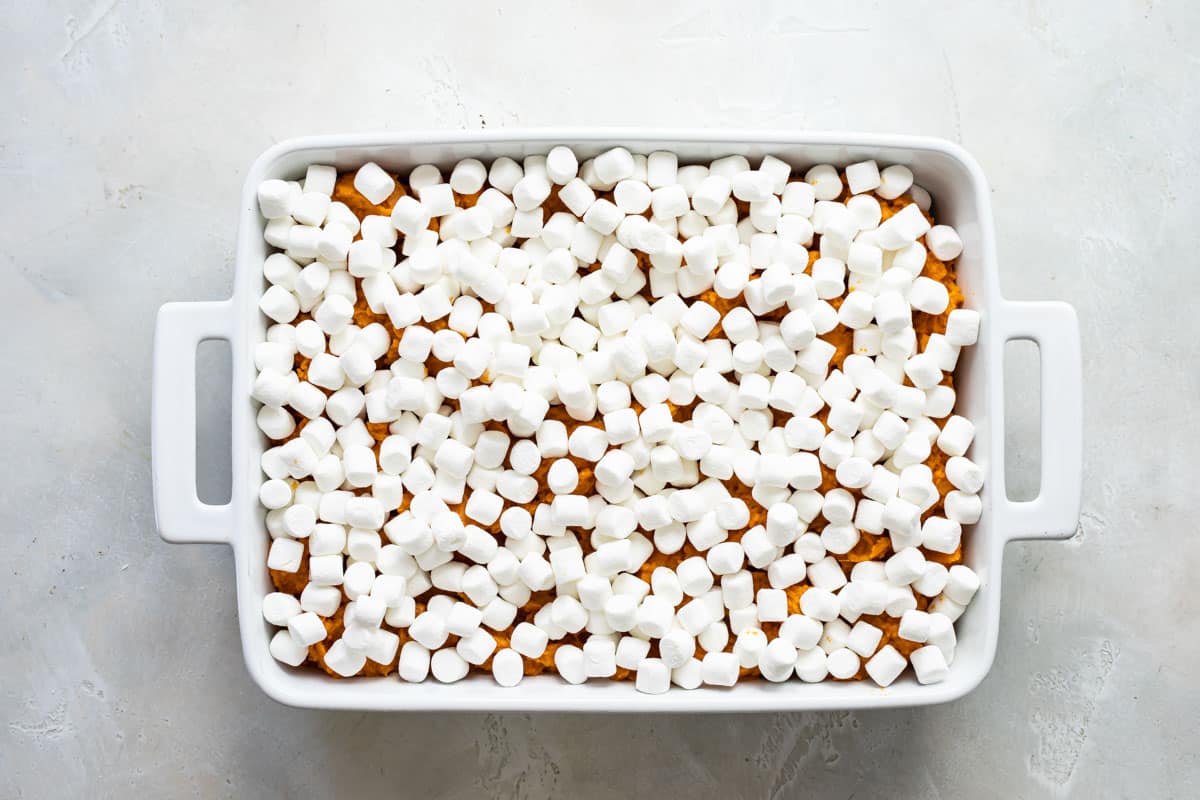 Sweet potato casserole in a white casserole dish before being baked.