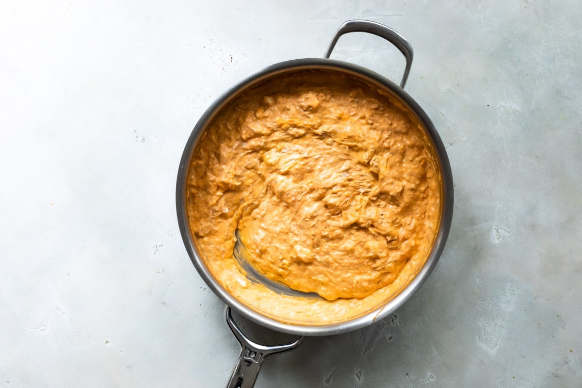 Buffalo chicken dip ingredients in a saucepan.