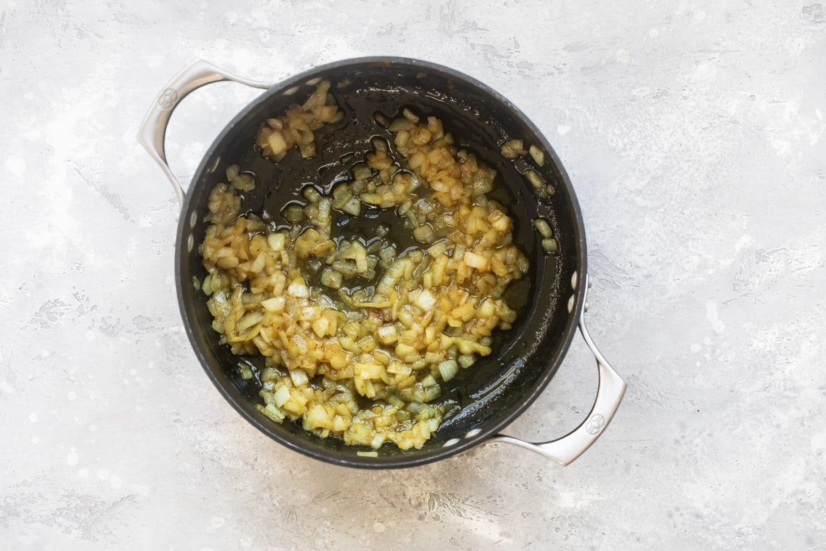 Cooking onions in bacon fat in a pot.