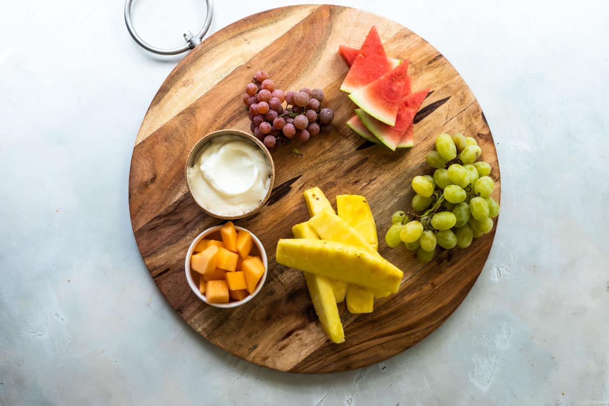 Building a fruit platter on a wooden board.