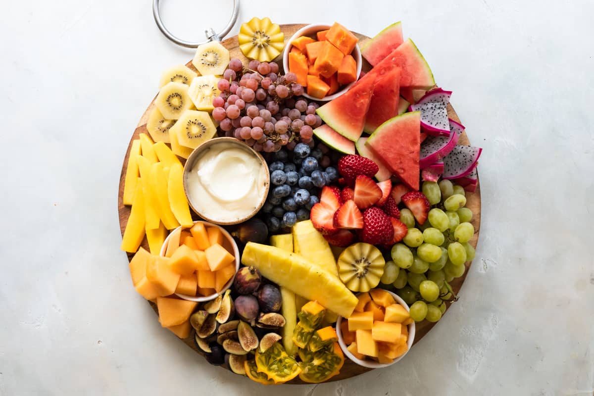 A platter of fresh fruit with fruit dip.