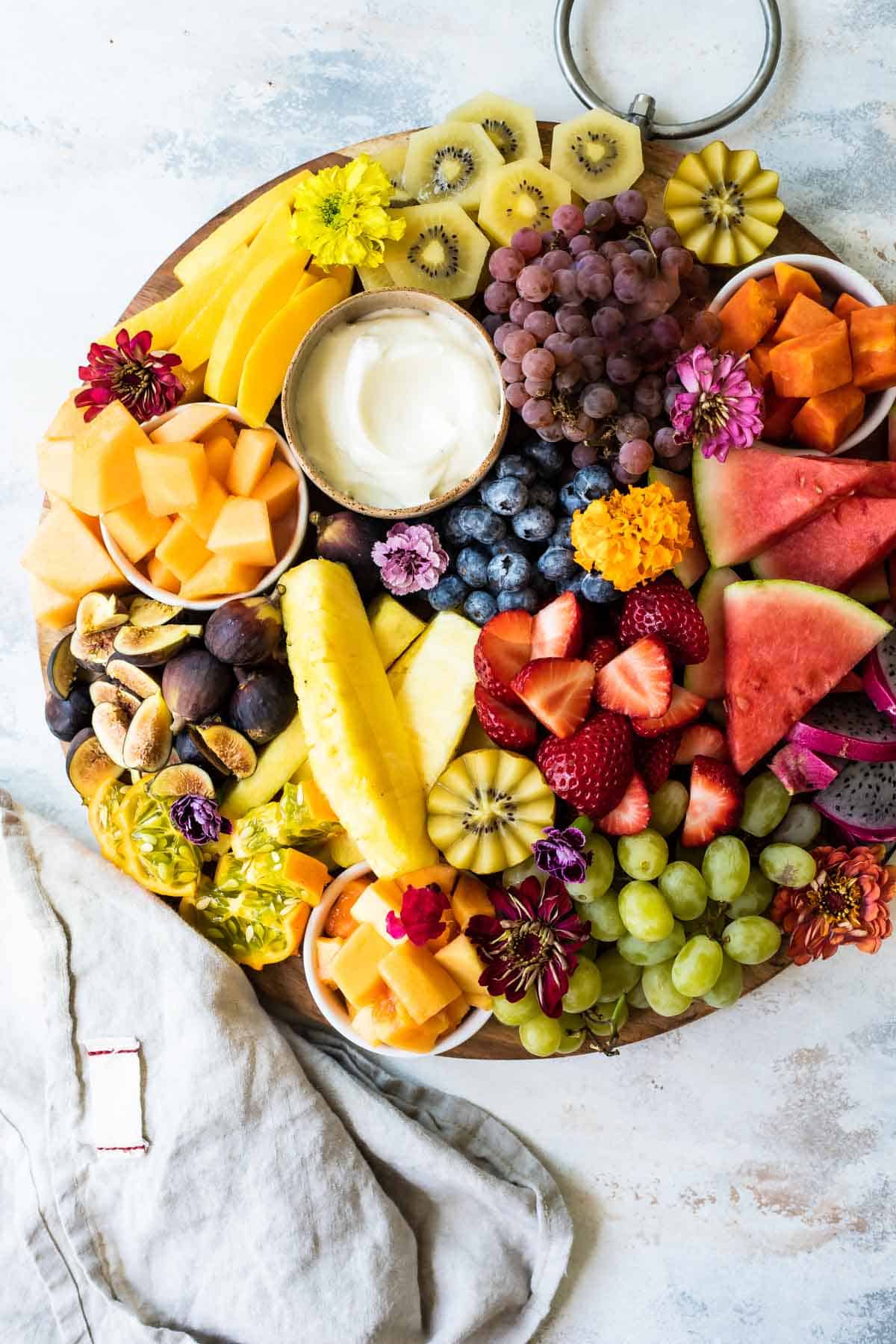 A platter of fresh fruit with fruit dip.