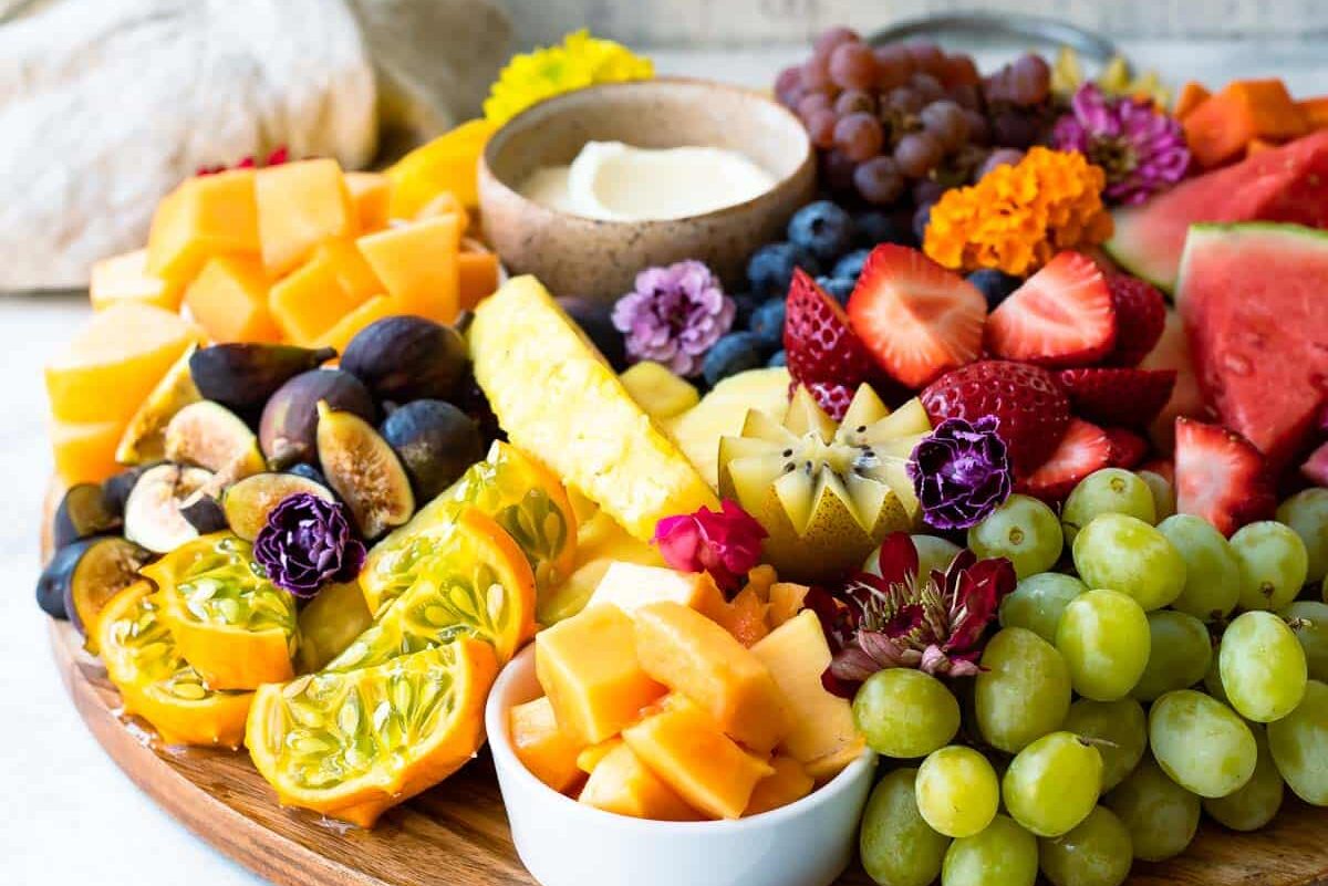 A platter of fresh fruit with fruit dip.
