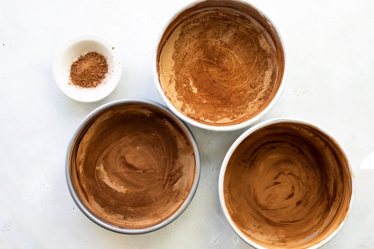 Prepared pans for 3 layers of chocolate cake.
