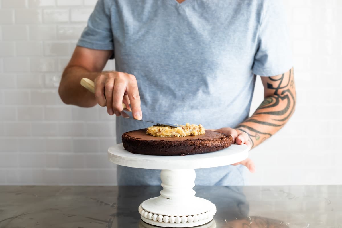 Putting caramel frosting on a German Chocolate Cake.