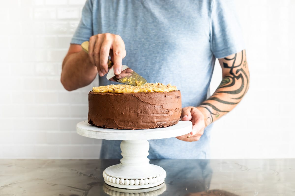 Putting caramel frosting on a German Chocolate Cake.