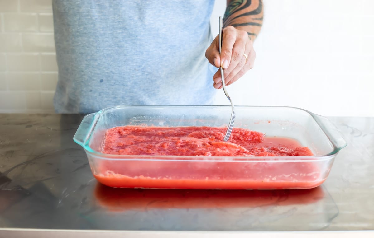 Scraping watermelon-flavored granita after freezing.