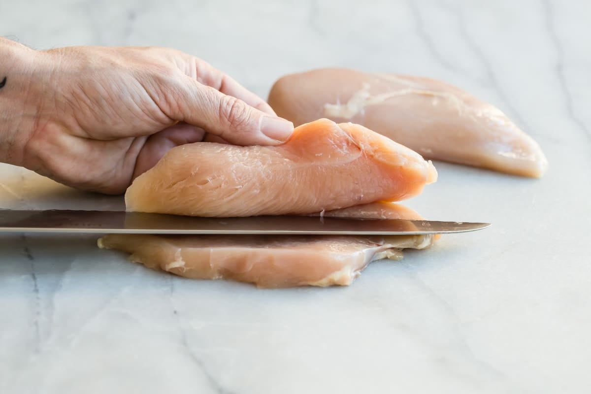 Butterflying a chicken breast in half.