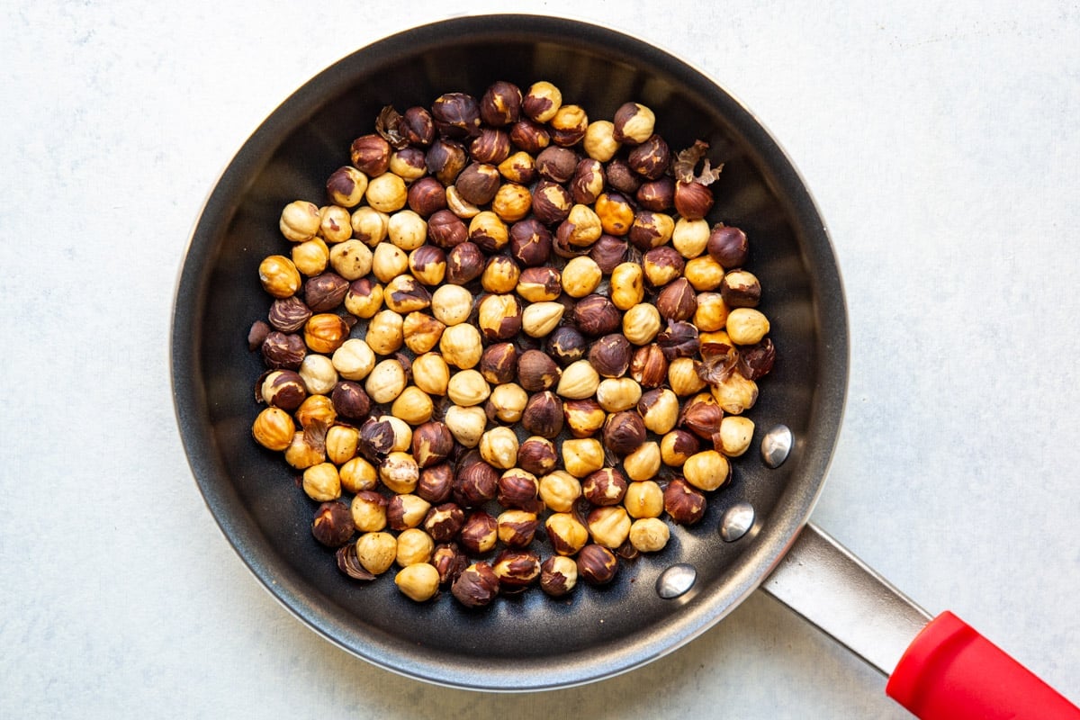 Roasted hazelnuts in a skillet.