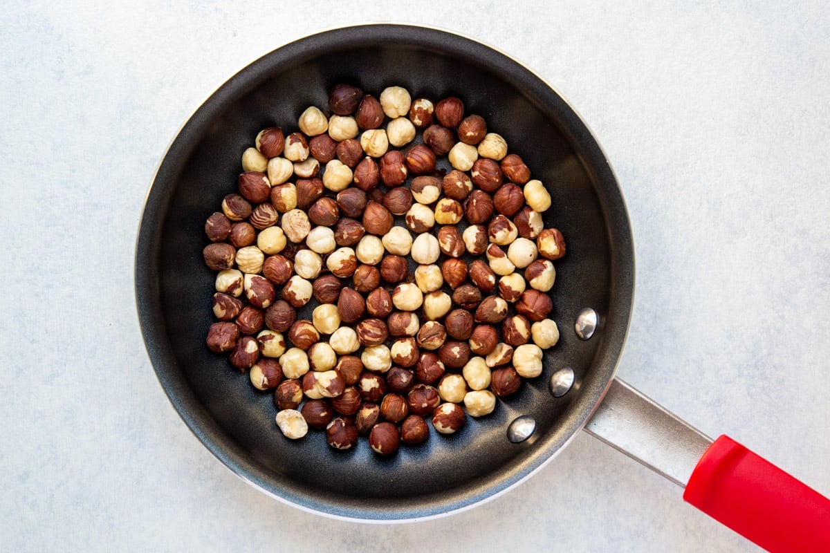 Raw hazelnuts in a skillet.
