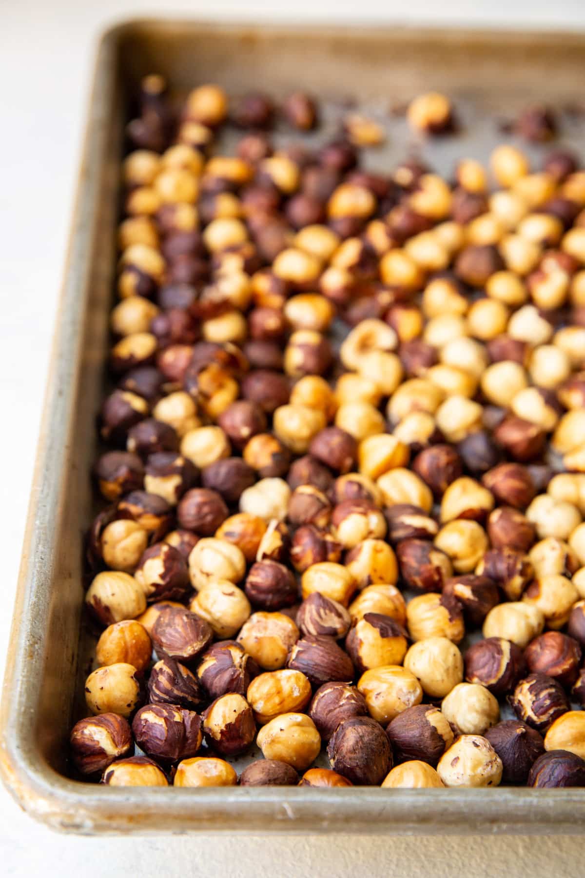 Hazelnuts roasted on a baking sheet.